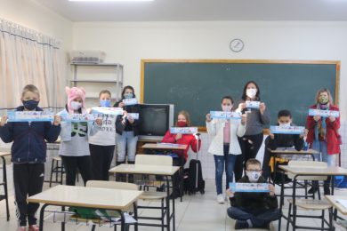 Grupo segurando os Carnês com arte da capa e contracapa feitos pelos alunos 